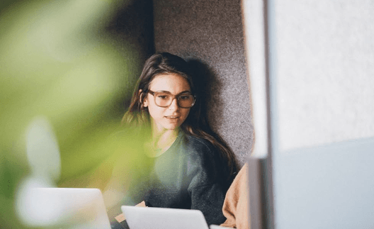 Женщина работает за ноутбуком, проходя карьерный коучинг